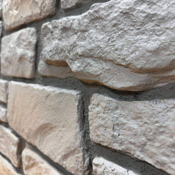 Close-up of Cotswold Stone in Fossil White showing the fossil-gray limestone texture and irregular stone faces