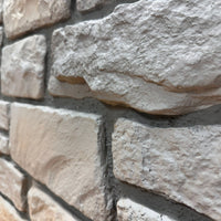 Close-up of Cotswold Stone in Fossil White showing the fossil-gray limestone texture and irregular stone faces